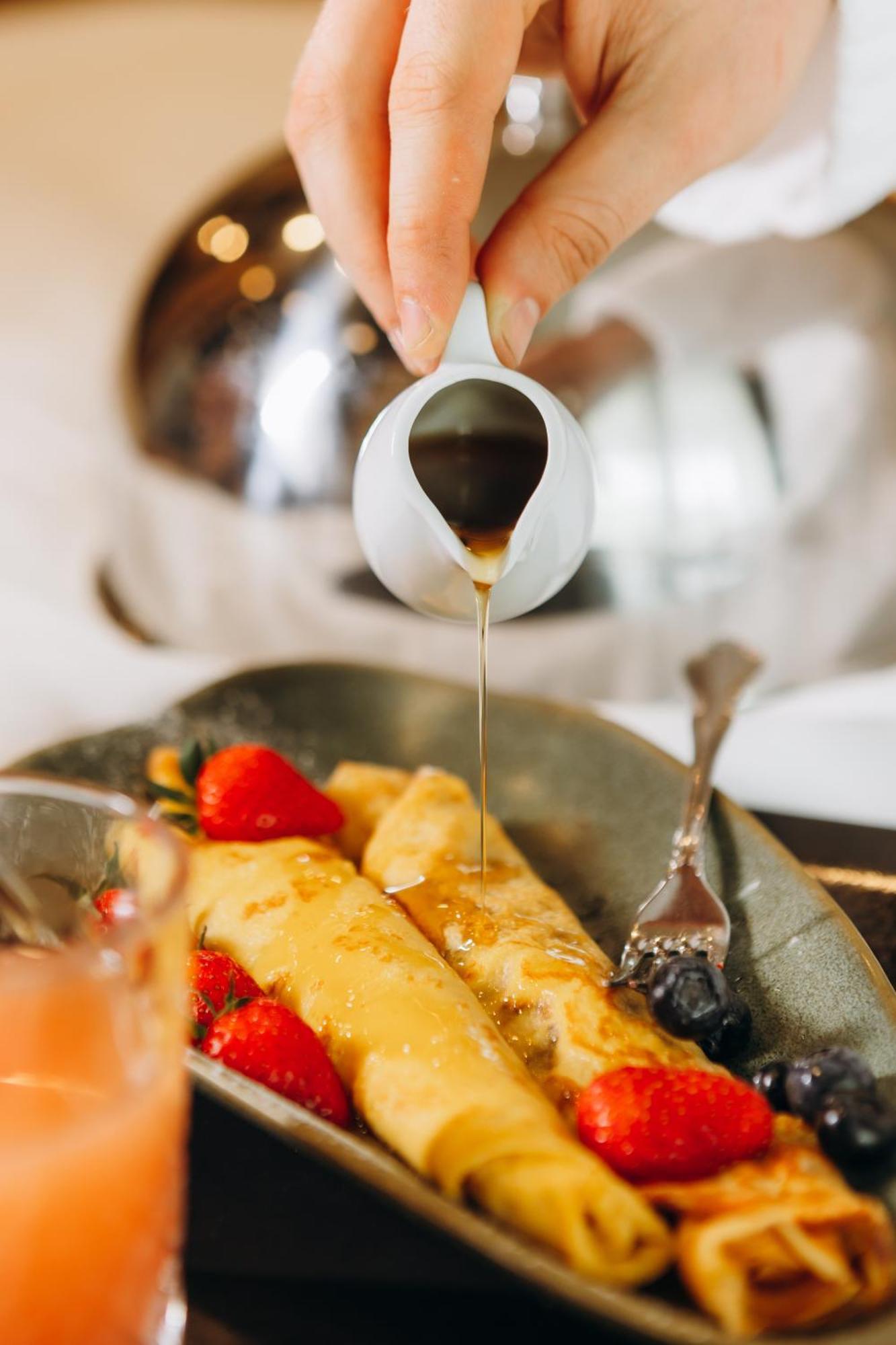 Hotel Platinia Cluj-Napoca Exteriör bild Maple syrup being poured onto crêpes