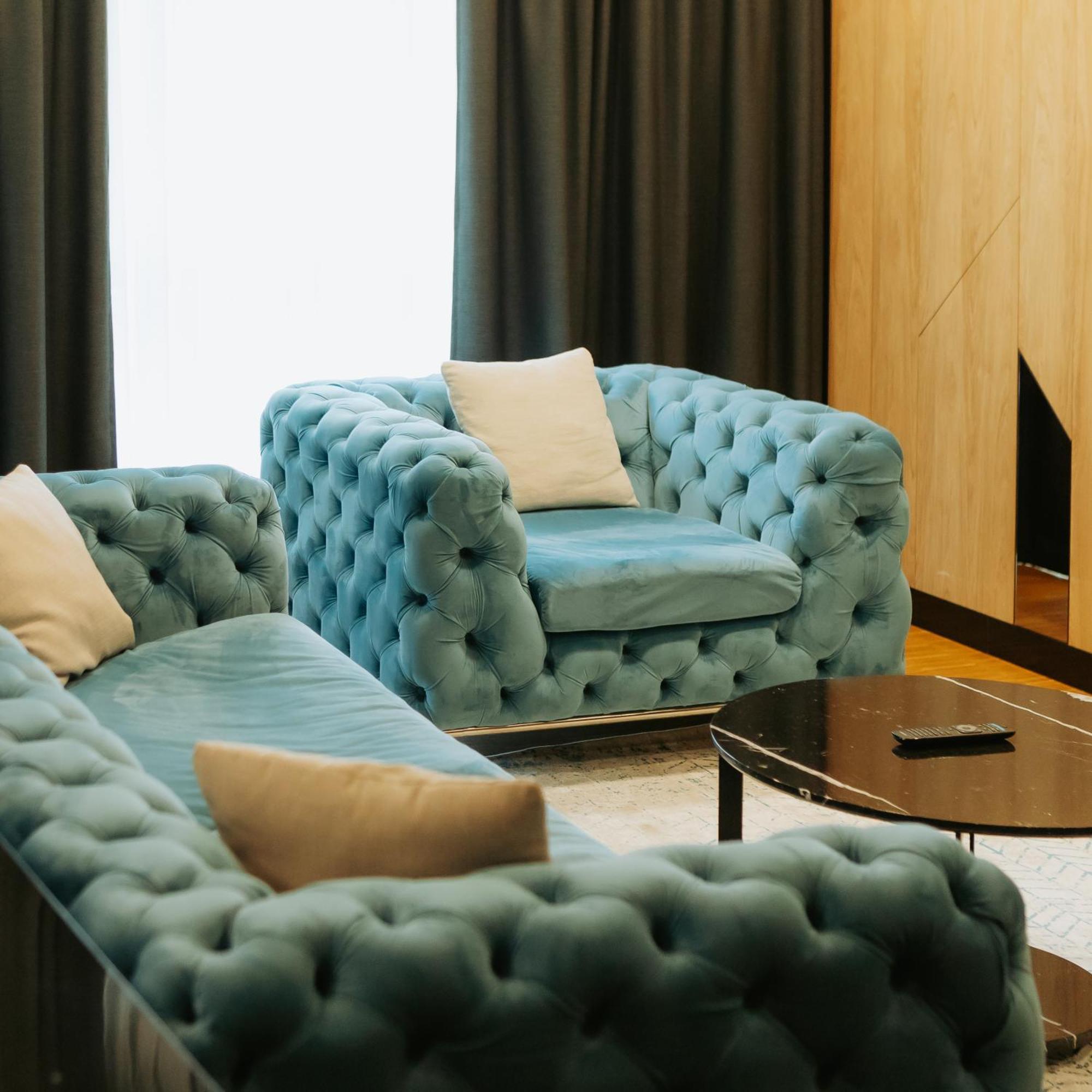 Hotel Platinia Cluj-Napoca Exteriör bild A blue velvet Chesterfield sofa